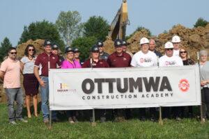 Group gathered behind Construction sign. 